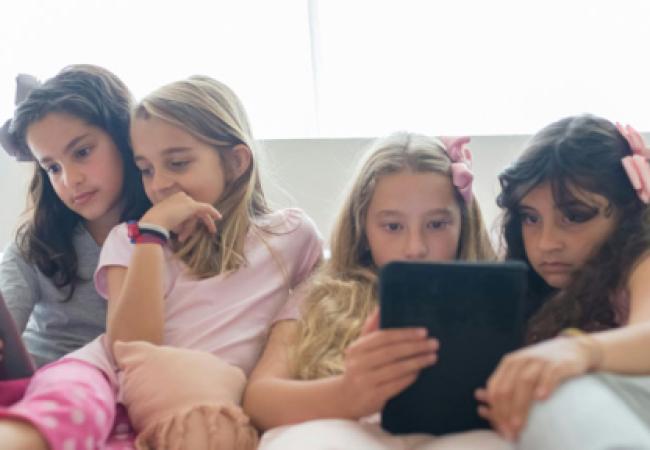 Young girls gazing at their mobile devices
