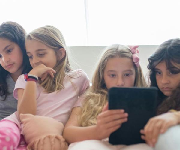Young girls gazing at their mobile devices